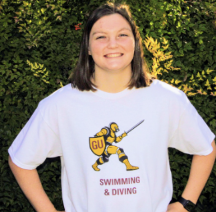Claire Rogillo standing proudly in her swimming and diving Gannon t-shirt.